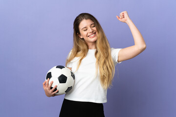 Young blonde football player woman isolated on purple background celebrating a victory