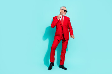 Photo of positive man pensioner dressed red three piece tux dark glasses dancing isolated teal...