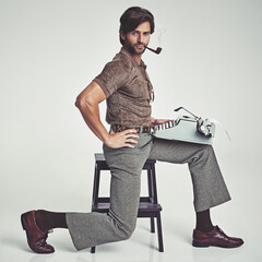 Multi-tasking to the max. Studio shot of a 70's style businessman sitting on a stool using a...