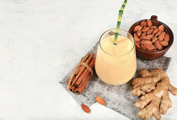 Indian almond yogurt lassi with spices, cinnamon and ginger on the old grunge background, probiotic fermented milk drink, natural dietary food, helps to combat infections and cancer, selective focus