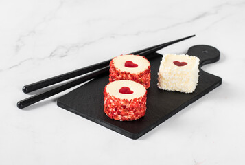 Festive Creamy white chocolate mousse cakes with jelly hearts, in the form of round and square sweet sushi, sprinkled with small pieces of freeze-dried strawberries and coconut chips. Valentine's Day