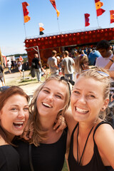 They're ready to join the party. Three young girls standing together and smiling at a music...