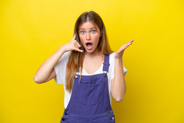 Fototapeta premium Young caucasian woman isolated on yellow background making phone gesture and doubting