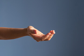 hand showing something on the palm, blue background