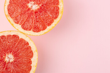Grapefruits on pink background, top view, flat lay