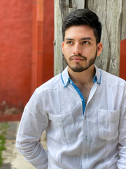 Model wearing an elegant white guayabera with blue details, traditional linen shirt from southeastern Mexico. 