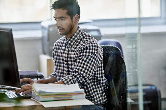 Coming up with a fool-proof plan. Cropped shot of a handsome young designer working on a pc.