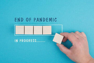 The words end of pandemic are standing on a blue background, stop of covid-19 regulations in...