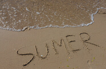 The inscription on the sand Summer symbolizes a summer vacation at the sea