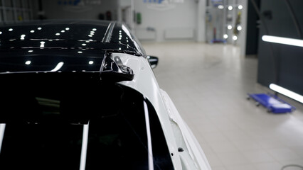 White car body. Vehicle detailing. Car under inspection maintenance repair. Electric car under repair.