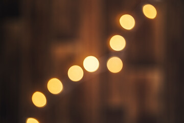 Out of focus wooden background with bokeh lights on it. Christmass abstract background. - obrazy, fototapety, plakaty