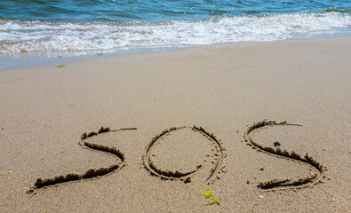 The inscription on the sand at the beach sos