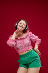 cheerful woman listening to music with headphones dance unaltered