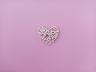  Postcard for lovers. Braided heart on a pink background.