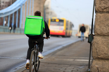 Kurier na rowerze, dostarcza jedzenie na moście Grunwaldzkim we Wrocławiu.	
