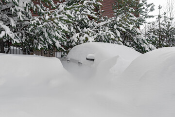 car covered with snow after a heavy snow storm.Vehicles are covered with snow during a heavy snowfall.