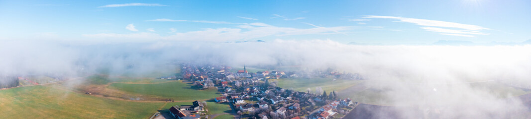 Obraz premium Ländliches Dorf in Bayern zu Sonnenaufgang im Nebel