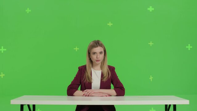 Female news presenter in broadcasting studio over green screen background