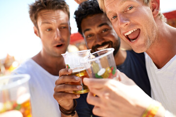 Let the partying begin. Three young men toasting their beers at a music festival.