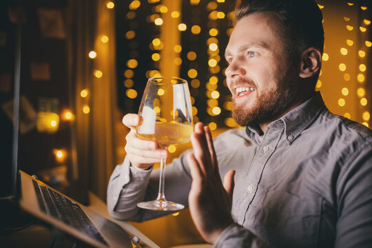 Man holding glass of white wine in hand. Concept web video conference or online party with family and friends