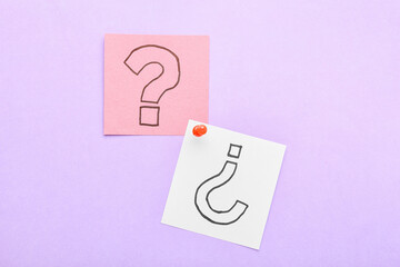Sticky notes with question marks and pin on lilac background
