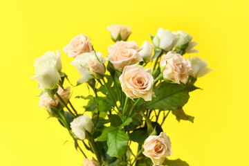 Bouquet of beautiful roses on yellow background