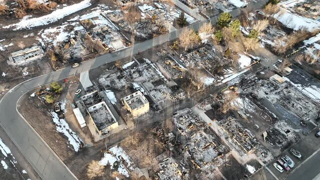 Aerial view of a whole neighborhood of houses burned down in a wildfire. Stock drone footage of aftermath of climate change fueled fire in suburban area.