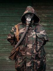 Woman with old gas mask and army jacket with a hood. Concept - Nuclear Disarmament and Radiation Protection, epidemic, coronavirus, covid-19, pandemic