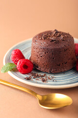 Plate with tasty lava cake fondant and raspberry on color background, closeup