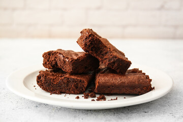 Plate with pieces of tasty chocolate brownie on table