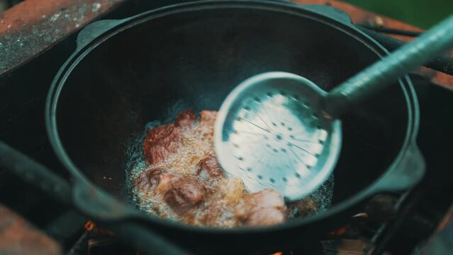 Step by step cooking of Pilaf in cauldron on fire.
