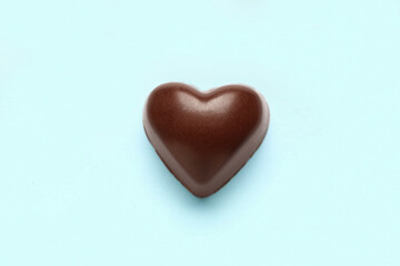 Tasty heart-shaped candy on blue background