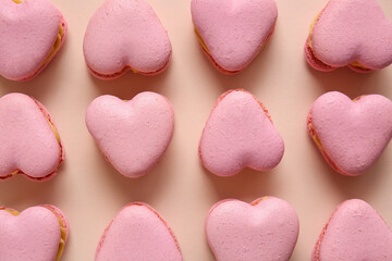Tasty heart-shaped macaroons on beige background