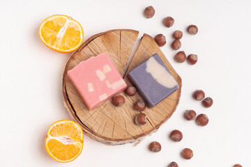 Handmade two soaps on wooden background. Natural soaps with orange and nuts smells. Top view