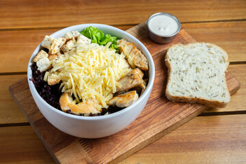 ensalada de pollo, lechuga, queso con salsa caesar
