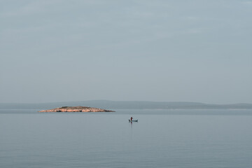 small island and the boat on calm sea
