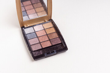 Old palette of shadows on light background. Space for text. Expired shelf life of cosmetics