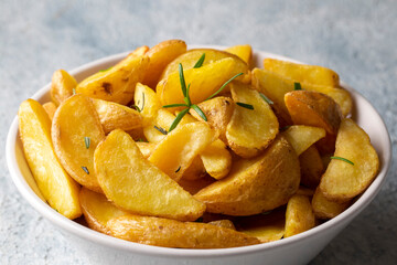 Roasted potato wedges with herbs and sea salt on plate, top view (Turkish name; elma dilim patates)