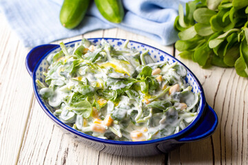 Purslane salad with yogurt in bowl on wooden background.