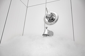 Bubble bath with single handle bathtub valve and spout filling tub from below and copy space