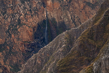 A waterfall falls from the walls of the Colca Canyon in Arequipa, Peru