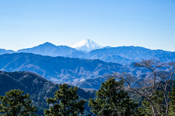 Fototapeta premium the landscape of snow-covered top of mount fuji, mountain ranges, and blue clear sky