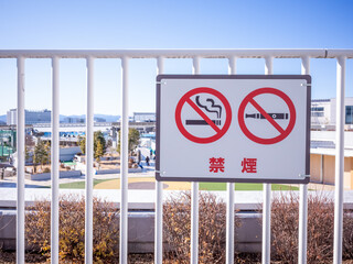 smoke prohibition sign displayed on the fence in the terrace in tokyo, translation: smoke prohibited