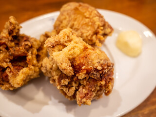 three pieces fried chickens on the white plate with mayonnaise 