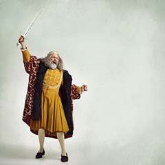 Once more into the breach. Studio shot of a richly garbed king brandishing a sword.