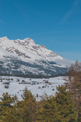 A picturesque vertical landscape view of the French Alps mountains on a cold winter day (La Joue du Loup, Devoluy)