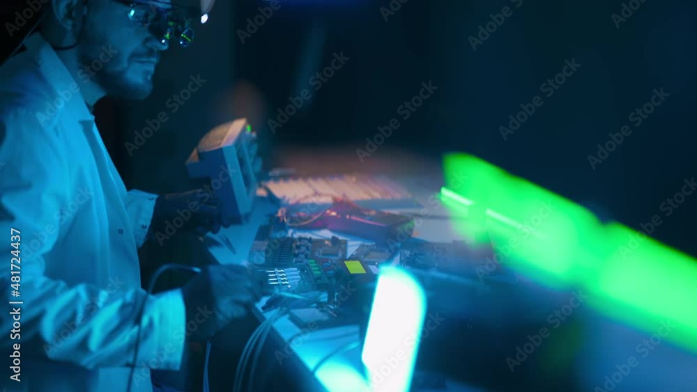 Poster technician engineer developer is soldering iron pcb microcircuit electronic component though magnifi