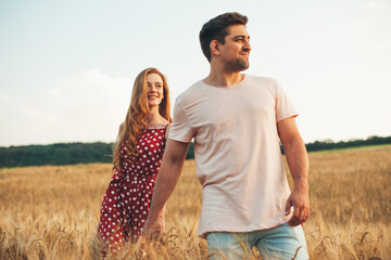 Front view of a couple holding hands and walking in wheat field. Wheat field. Holding hand.