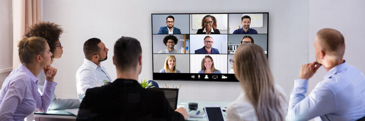 Businesspeople Video Conferencing In Boardroom