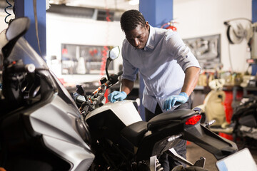 Fototapeta na wymiar Mechanic is repairing modern moto in the workshop. High quality photo